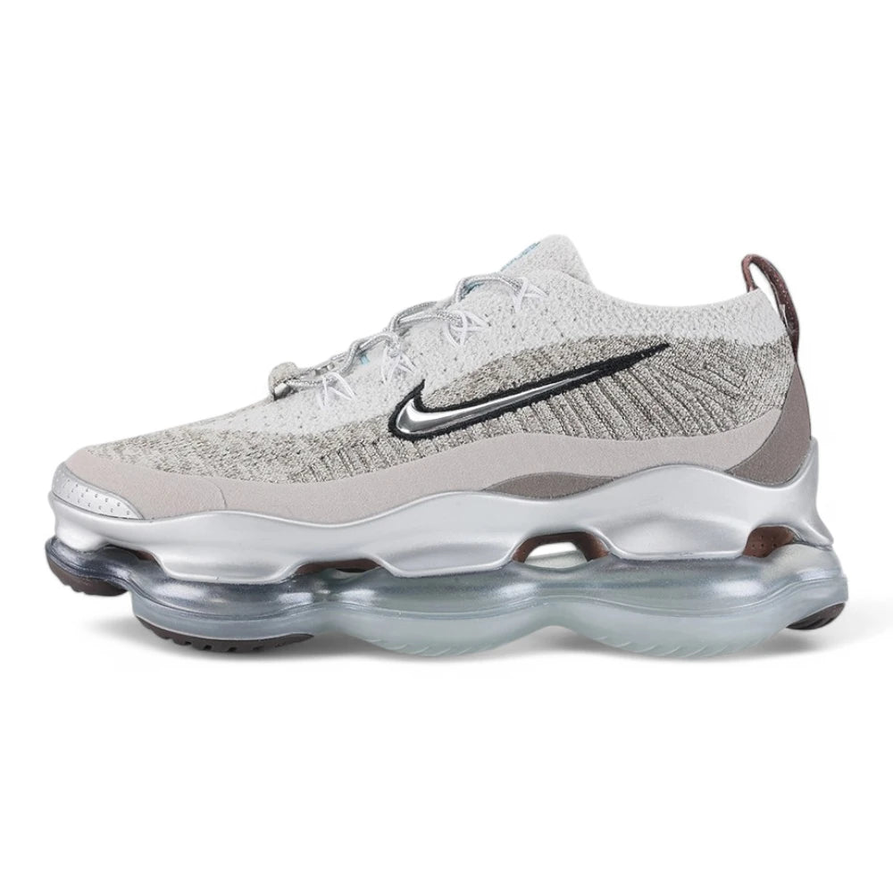 Air Max Scorpion Flyknit Gaiter Light Bone Metallic Silver - Full Lateral Profile View on Grey Background Showing Heathered Light Bone Warm Grey Speckle Flyknit Upper Light Bone Perforated Suede Overlay Black Filled Swoosh Embroidery Silver Metallic Rope Lace Powder Blue Lace Garage Smoky Mauve Terry Gaiter at Heel Collar and Large-Volume Metallic Silver AM Scorpion Air Unit
