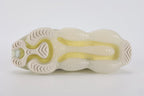 Air Max Scorpion Flyknit Lemon Wash Light Orewood Brown Lemon Chiffon - Heel Pull Tab Close Up on White Background Showing Lemon Chiffon Wide Heel Pull Tab with Black Dot-Grid Texture on Both Lateral and Medial Sides Boucle Flyknit Heel Counter and Frosted Ice AM Scorpion Air Unit at Heel with Lemon Chiffon and Volt Air Chambers Visible