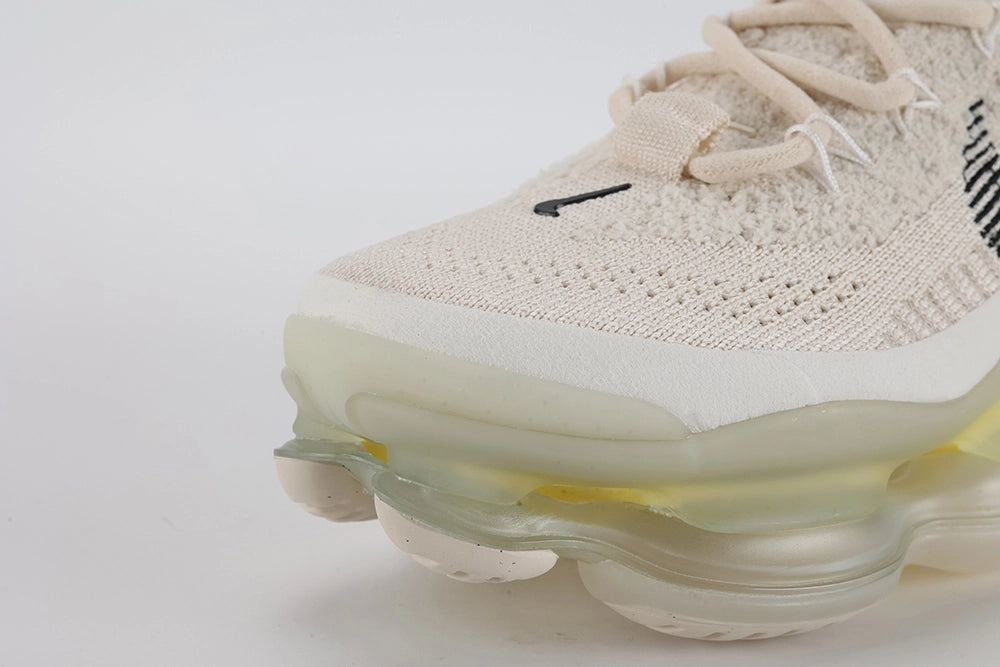 Air Max Scorpion Flyknit Lemon Wash Light Orewood Brown Lemon Chiffon - Toe Box Three-Quarter View on White Background Showing Light Orewood Brown Boucle Flyknit Upper Black Mini Swoosh on Toe Box Silver Oval Lace Keepers and Frosted Ice AM Scorpion Air Unit at Forefoot