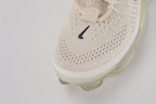 Air Max Scorpion Flyknit Lemon Wash Light Orewood Brown Lemon Chiffon - Rear View of Both Shoes on White Background Showing Lemon Chiffon Wide Heel Pull Tabs with Black Dot-Grid Texture on Both Sides Lemon Chiffon Collar Lining Boucle Flyknit Heel Counter and Frosted Ice AM Scorpion Air Unit with Lemon Chiffon and Volt Air Chambers at Heel