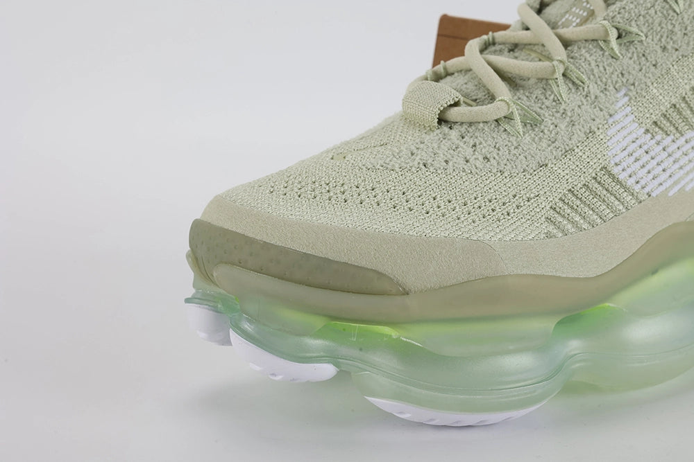 Air Max Scorpion Flyknit Olive Aura Light Bone Sea Glass Volt - Toe Box Top Down View on Grey Background Showing Light Bone Fine-Knit Flyknit Toe Box Light Bone Tonal Mini Swoosh Embroidery Tan Leather Lace Garage Two Light Bone Rectangular Lace Keepers with White Dot-Grid Texture and Light Bone Rope Laces