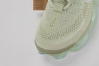 Air Max Scorpion Flyknit Olive Aura Light Bone Sea Glass Volt - Lace Area Close Up on Grey Background Showing Two Light Bone Rectangular Lace Keepers with White Dot-Grid Texture Tan Leather Lace Garage Light Bone Rope Laces White Sketch-Outline Swoosh on Lateral Midfoot Boucle Flyknit with Silver Metallic Thread and Sea Glass AM Scorpion Air Unit