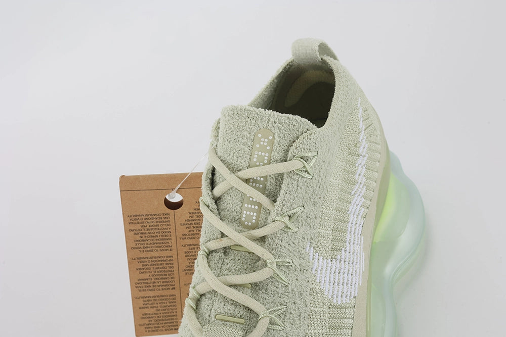 Air Max Scorpion Flyknit Olive Aura Light Bone Sea Glass Volt - Rear View of Both Shoes on Grey Background Showing Light Bone Wide Rubber Heel Pull Tabs Tan Leather Heel Tab at Collar Top Light Bone Boucle Flyknit Heel Counter and Sea Glass to Volt Gradient AM Scorpion Air Unit at Heel with Volt Chambers Visible