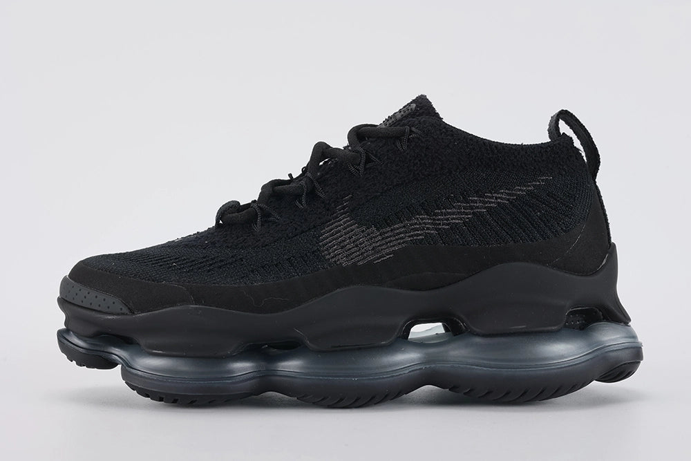 Air Max Scorpion Flyknit Triple Black Anthracite - Toe Box Close Up on Grey Background Showing Black Fine-Knit Flyknit Toe Box Anthracite Mini Swoosh Embroidery Black Perforated Suede Overlay at Lower Zone with Dense Small-Circle Perforation Pattern and Black AM Scorpion Air Unit at Forefoot