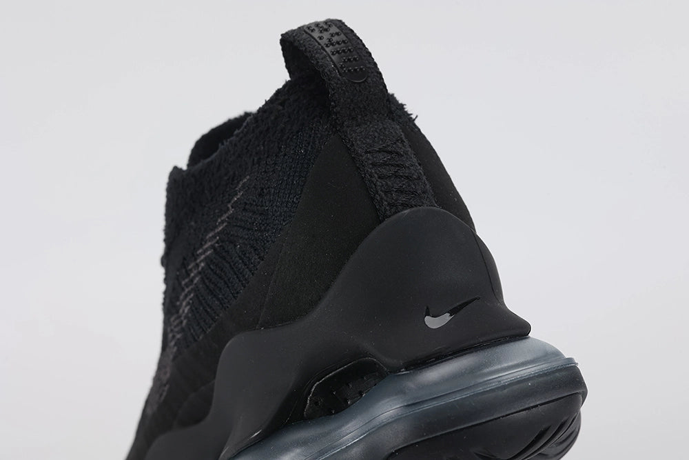 Air Max Scorpion Flyknit Triple Black Anthracite - Rear View of Both Shoes on Grey Background Showing Black Terry Loop-Pile Flyknit Heel Counter Black Wide Rubber Heel Pull Tabs with Black Dot-Grid Texture Black Collar Lining Anthracite Mini Swoosh on Midsole Heel Counter and Black to Dark Smoke Grey AM Scorpion Air Unit at Heel with Dark Smoke Grey Chambers Visible