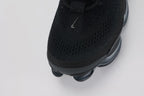 Air Max Scorpion Flyknit Triple Black Anthracite - Full Both Shoes Lateral Three-Quarter View on Grey Background Showing Four-Texture Black Flyknit Upper Black Iridescent Lateral Panel Black Perforated Suede Overlay Black Rope Laces and Black to Dark Smoke Grey AM Scorpion Air Unit