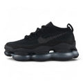 Air Max Scorpion Flyknit Triple Black Anthracite - Full Lateral Profile View on Grey Background Showing Four-Texture Black Flyknit AM Scorpion Upper Black Iridescent Flyknit on Lateral Midfoot Upper Zone Black Perforated Suede Overlay at Lower Zone Anthracite Mini Swoosh on Toe Box Black Rope Laces and Black to Dark Smoke Grey AM Scorpion Air Unit