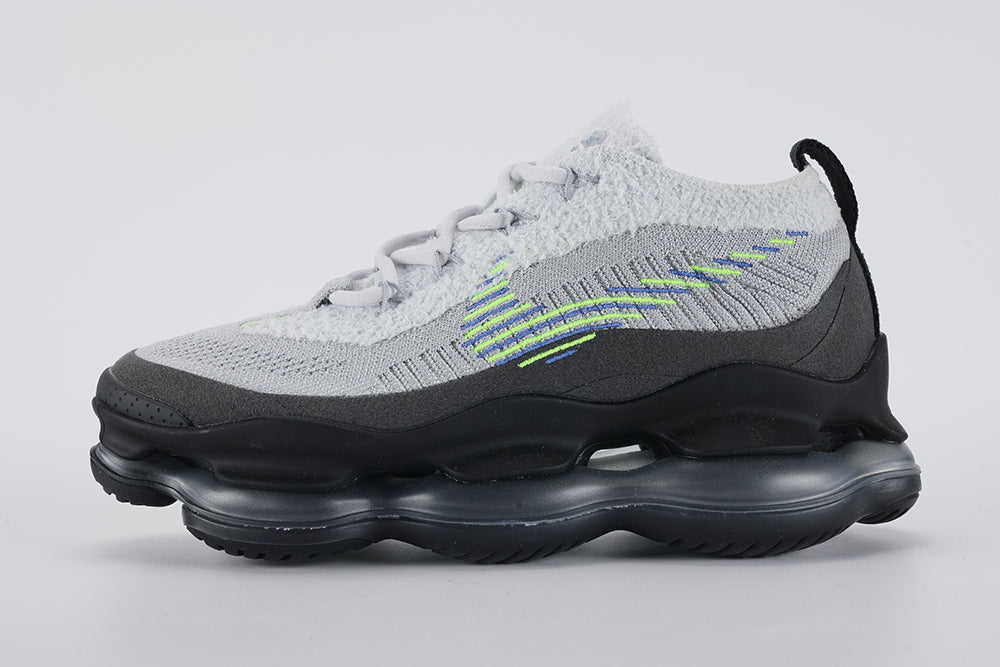 Air Max Scorpion Flyknit Wolf Grey Volt Racer Blue Black - Toe Box Close Up on Grey Background Showing Wolf Grey Fine-Knit Flyknit Toe Box Volt Neon Yellow Mini Swoosh Embroidery Dark Grey Perforated Suede Overlay with Dense Small-Circle Perforation Pattern and Black AM Scorpion Air Unit at Forefoot