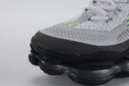 Air Max Scorpion Flyknit Wolf Grey Volt Racer Blue Black - Toe Box Top Down View on Grey Background Showing Wolf Grey Fine-Knit Flyknit Toe Box Volt Mini Swoosh Dark Grey Perforated Suede Overlay White Flat Laces and Volt and Racer Blue Knit Stripes on Lateral Midfoot Flyknit