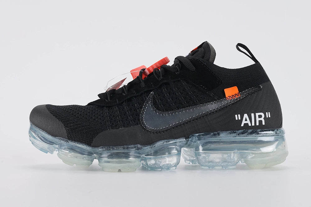Air VaporMax co-branded Part 2 Black White Orange - Toe Box Close Up on White Background Showing Black Fine-Knit Flyknit Toe Box Dark Grey Flyknit Zone at Lower Lateral Midfoot Orange Industrial Zip Tie and Frosted Ice VaporMax Cylindrical Air Chamber Array at Forefoot