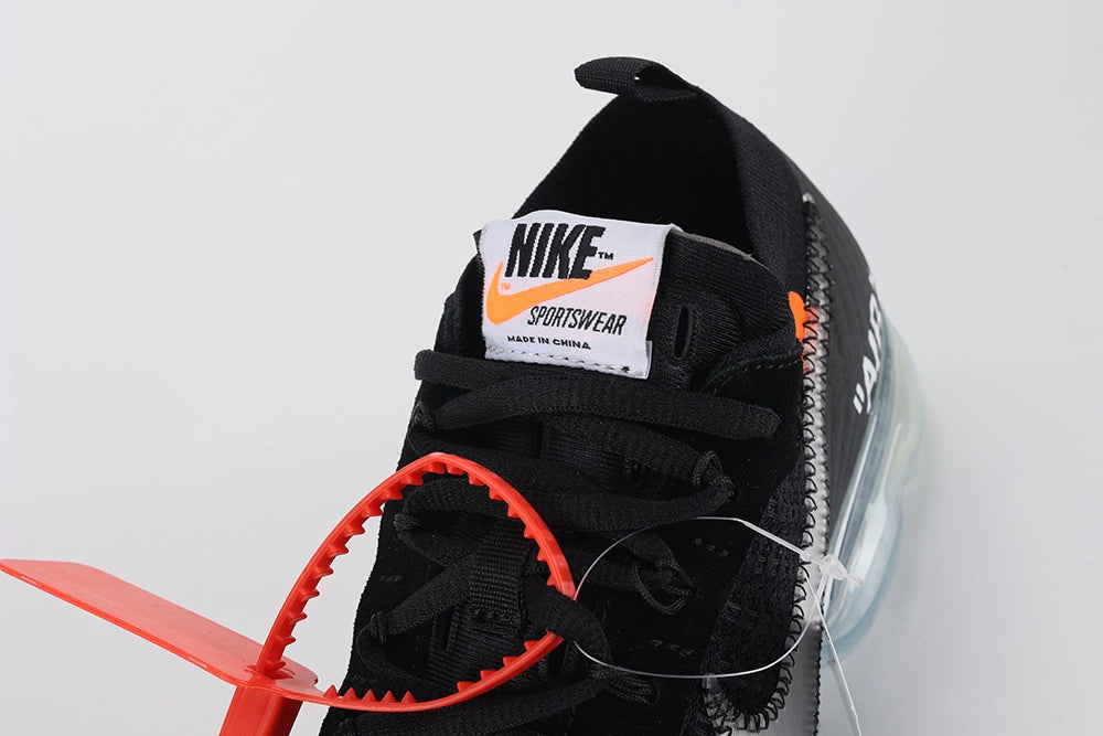 Air VaporMax co-branded Part 2 Black White Orange - Both Shoes Three-Quarter Lateral View on White Background Showing Full Upper Profile Black Flyknit Silver Swoosh Orange Zip Tie White Tongue Label and Frosted Ice VaporMax Air Unit