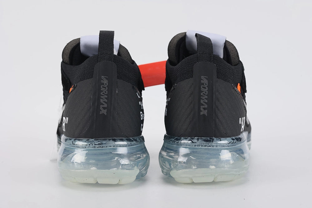 Air VaporMax co-branded Part 2 Black White Orange - Full Outsole View on White Background Showing Frosted Ice Semi-Transparent VaporMax Cylindrical Air Chamber Array Glow-in-Dark Phosphorescent Green Forefoot Air Chamber Bases White Mini Swoosh on Forefoot Air Base and Dark Grey Inner Base Plate with Horizontal Texture