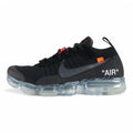 Air VaporMax co-branded Part 2 Black White Orange - Full Lateral Profile View on White Background Showing Black Fine-Knit Flyknit Upper Silver Large Swoosh with Black Edge Stitching Orange Industrial Zip Tie with Transparent Plastic Hang Tag Black Rope Laces White Woven Tongue Label with Orange Swoosh and Frosted Ice VaporMax Air Unit